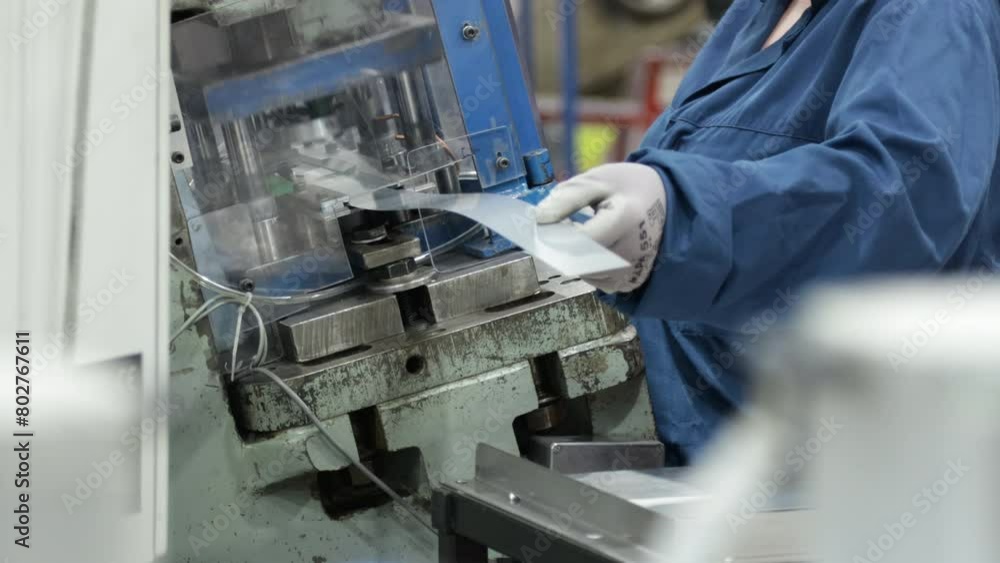 female worker wearing protective gloves working on a power press machine inside a modern factory close up low angle established female worker wearing protective gloves working on a power press machine inside a modern factory close up low angle established