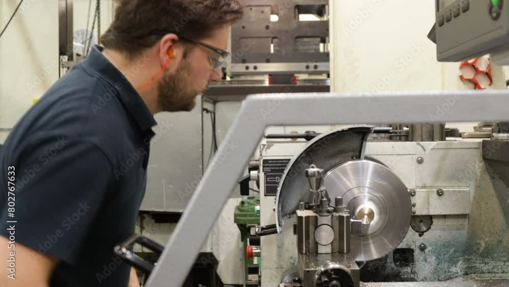 Worker operating A Lathe In A Metal Fabrication Plant Worker operating A Lathe In A Metal Fabrication Plant