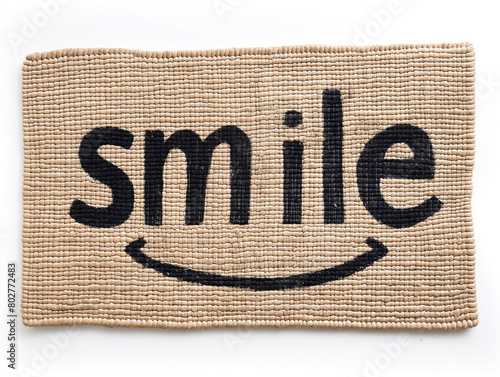 Handmade coir doormat with the word SMILE in black stenciled letters photo