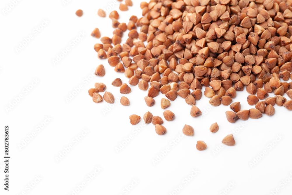 Brown buckwheat grains pile on white background. Dry buckwheat grains. Top view Brown buckwheat grains pile on white background. Dry buckwheat grains. Top view