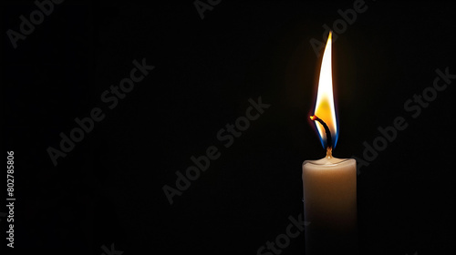 Burning white candle on black background. Close-up photo. With copy space. Image for memory of events and people
