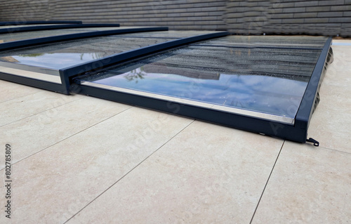 folding pool roof. the cover made of aluminum and plexiglass runs on rails. protects the pool from dirt from the environment and prevents heat leakage and helps to accumulate heat from the sun