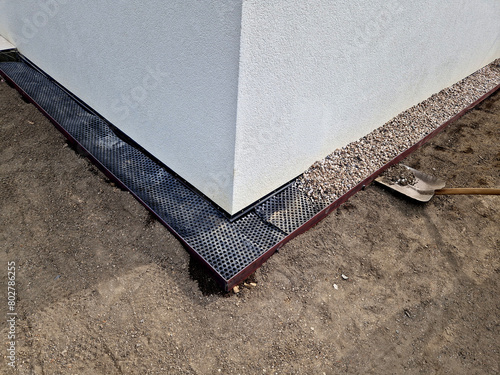 around the house it is always necessary to create a gutter path made of gravel and pebbles. serves  absorb water and ventilate the walls of the house. installation of curb steel sheets. membrane foil photo