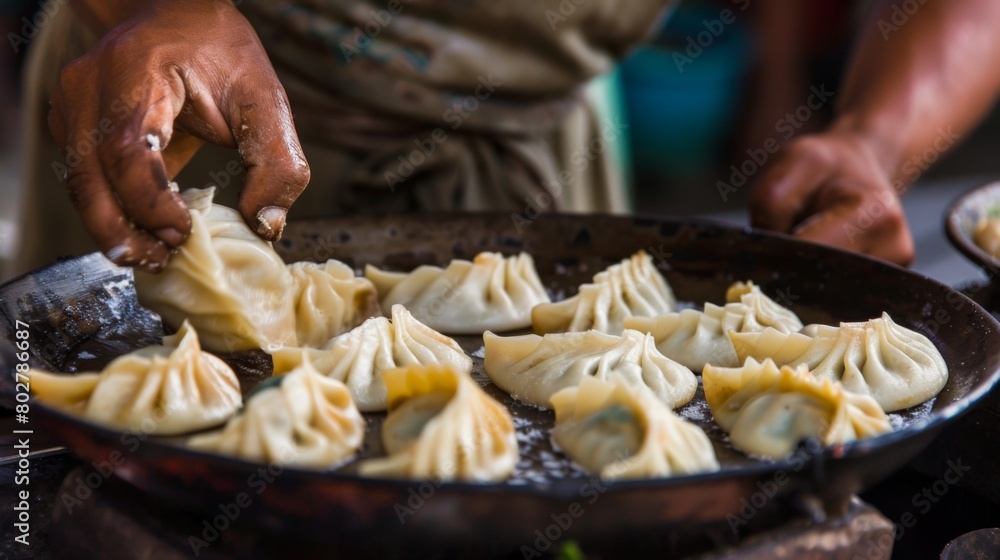 An Indian cook carefully pinching the edges of momo wrappers to create intricate patterns, adding an artistic touch to the dish.