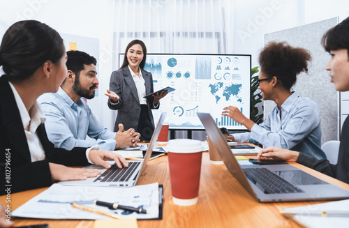 Young asian businesswoman presenting data analysis dashboard on TV screen in modern meeting. Business presentation with group of business people in conference room. Concord