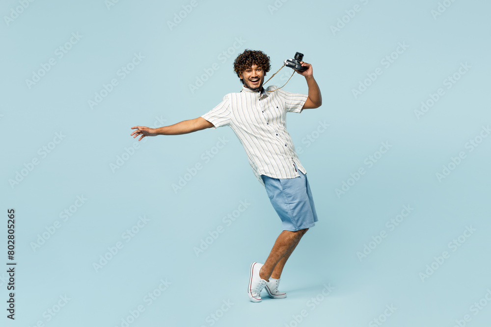 Full body traveler Indian man wear white casual clothes stand on toes lean back isolated on plain blue background Tourist travel abroad in free spare time rest getaway Air flight trip journey concept Full body traveler Indian man wear white casual clothes stand on toes lean back isolated on plain blue background Tourist travel abroad in free spare time rest getaway Air flight trip journey concept