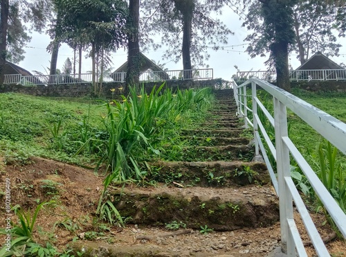 A white fenced staircase leads to the hotel in the tourist area