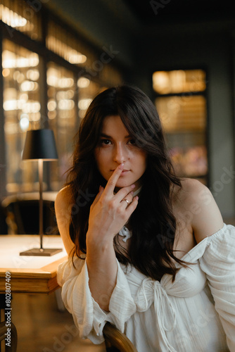 portrait of a pretty woman sitting alone at a restaurant table