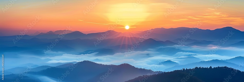 a stunning sunset over a mountain range, with a vibrant orange sky and a bright yellow sun setting