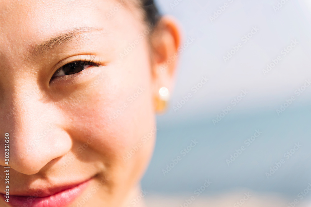 Fototapeta premium close up of the eye of a cute asian woman smiling happy looking at camera, concept of beauty and purity