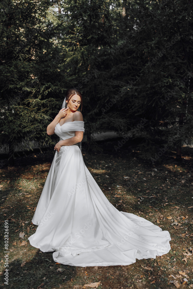 A woman in a white dress is standing in a forest