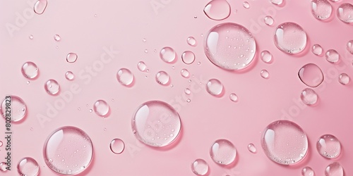 Beauty product backdrop. Close-up of water or collagen drops on a pink surface, ideal for showcasing skincare or cosmetic products.