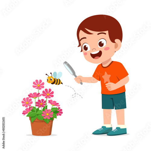 little kid use magnifying glass to observe bee