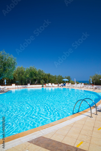 Swimming pool on sunny day by sea