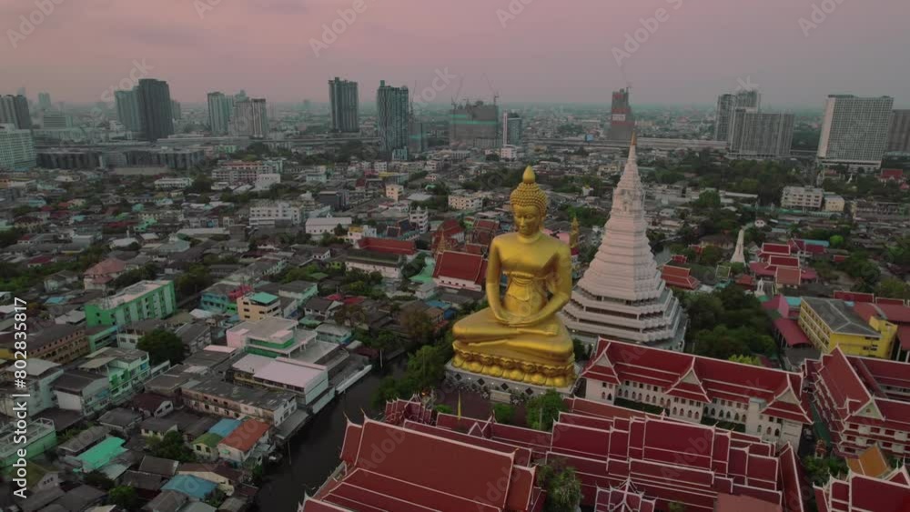 A giant golden buddha statue in urban bangkok at dusk, serene atmosphere, aerial view