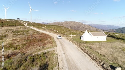 Car Traveling in Mountain Road With Wind Turbine Aerial View photo