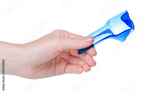 Measuring spoon for washing powder in hand on white background isolation