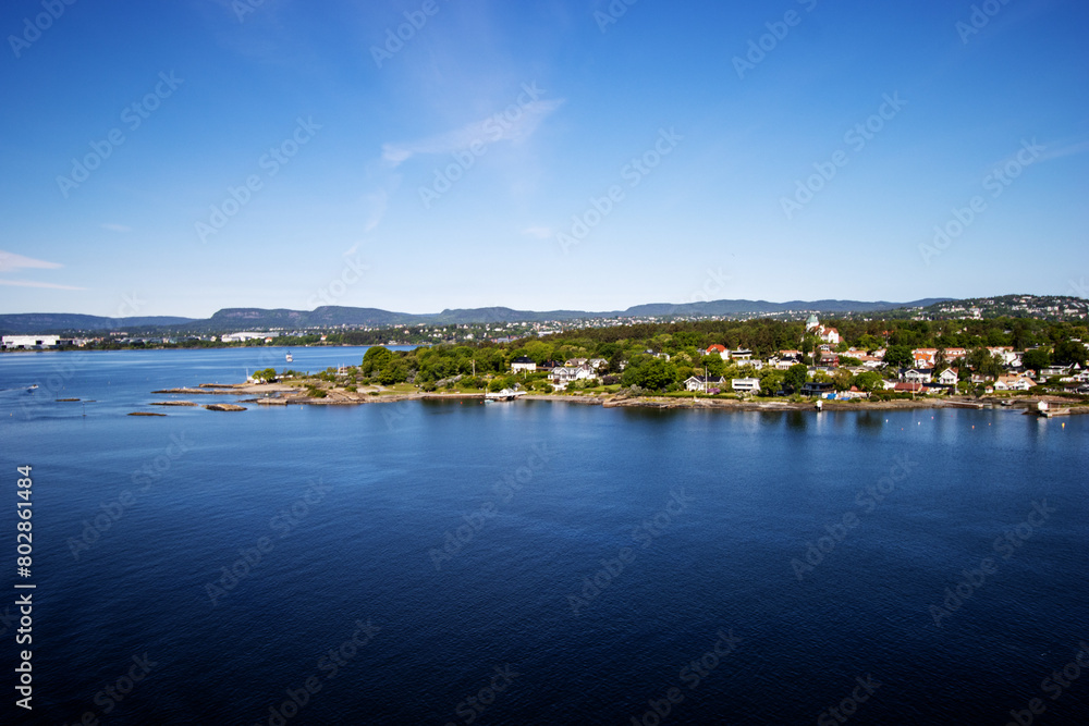 the Inner Oslofjord, near Oslo, Norway on a clear day with dark blue sea and sky with wooded hills and red roof houses
