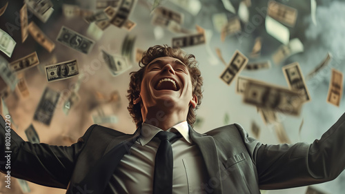 handsome young businessman is happy, throwing money in the air, wearing suit . The background of falling dollars in motion blur