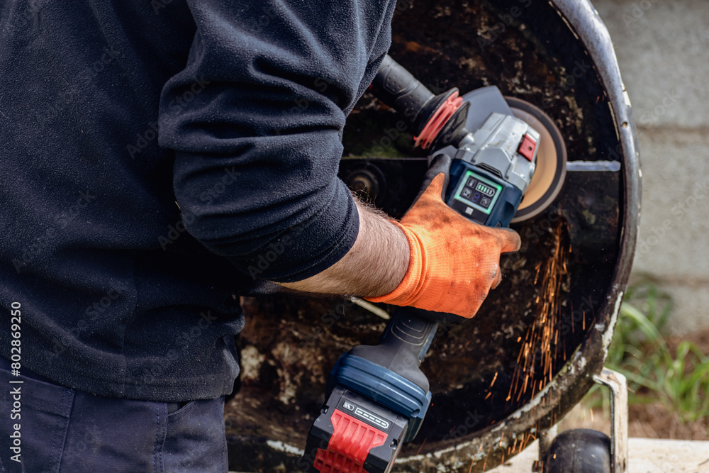 Man using portable grinder with sparkles Man using portable grinder with sparkles