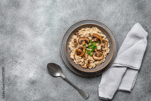 Risotto with mushrooms on a gray grunge background. Italian dish. Top view, flat lay, copy space.