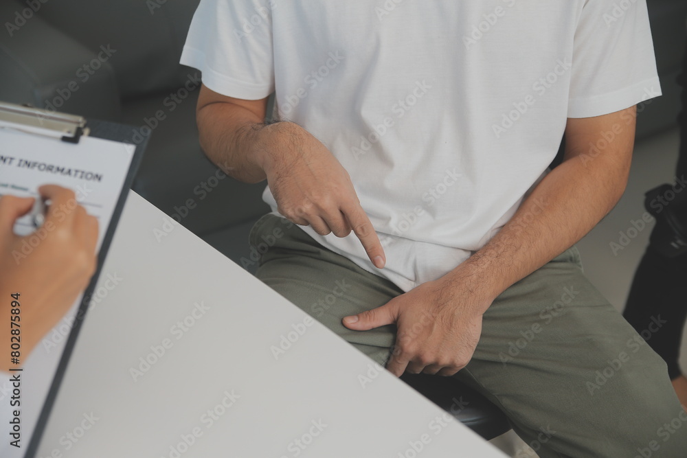 Male diseases. Man presses hands to his groin and suffering from pain, panorama, cropped, studio shot