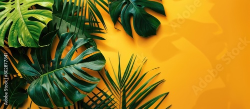 Tropical green leaves with a leaf design on a sunny yellow backdrop  representing the essence of summer. Presentation in a flat lay style with top view  providing ample space for text 