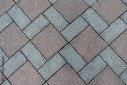 View of geometric pavement made of grey and brown concrete tiles from above