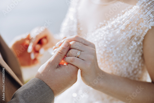 A man and woman are holding hands and wearing wedding rings. Concept of love and commitment, as the couple is getting married