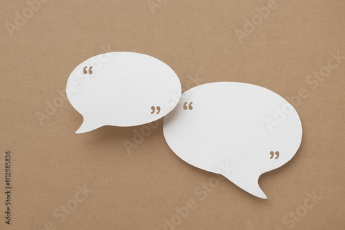 Conceptual image about communication and social media, customer feedback, couple real blank white speech bubble paper cut on grunge brown color background