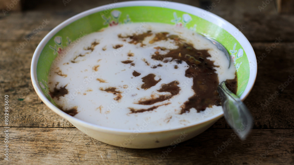 a bowl of green bean porridge with coconut milk sauce. bubur kacang ijo or mung beans porridge. The ingredients are mung beans a bowl of green bean porridge with coconut milk sauce. bubur kacang ijo or mung beans porridge. The ingredients are mung beans