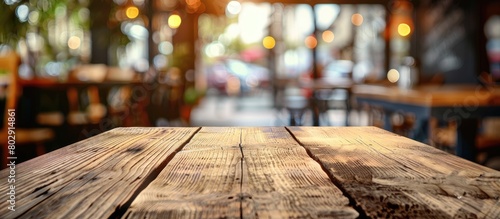 An empty wooden table set against a blurred cafe and bistro background, ideal for product placement.