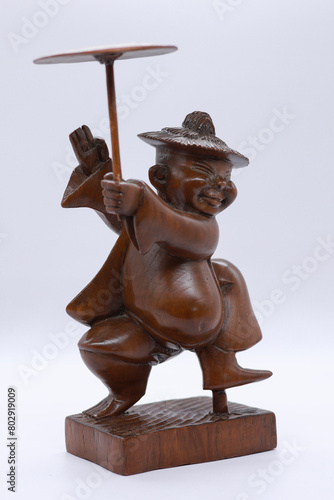 Adorable miniature wooden statue depicting traditional Burmese people, reflecting Myanmar's rich culture and heritage.