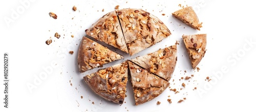 Circular baked bread with bran pieces, cut and positioned separately against a white backdrop. Seen from above.