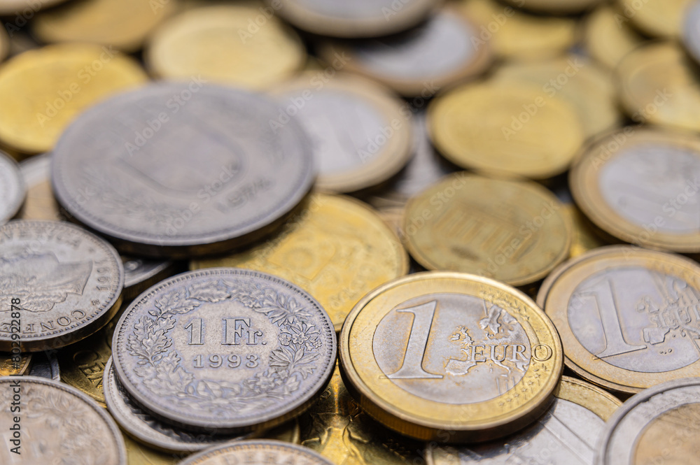 Euro and Swiss Franc coins next to each other, 1 euro and 1 CHF coins Euro and Swiss Franc coins next to each other, 1 euro and 1 CHF coins