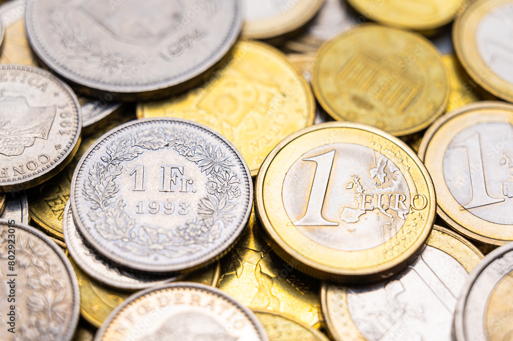 Euro and Swiss Franc coins next to each other, 1 euro and 1 CHF coins Euro and Swiss Franc coins next to each other, 1 euro and 1 CHF coins