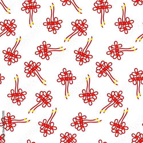 A pattern of red threads is tied into Chinese knots for good luck, symbolizing prosperity. Red threads in knots with gold beads. Materials in the traditional Asian style are used in cultural