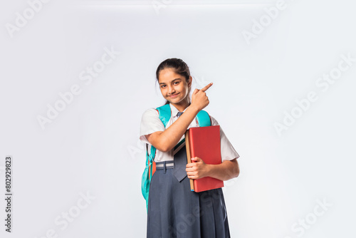 Asian Indian teenage schoolgirl in school uniform with different expressions standing against white