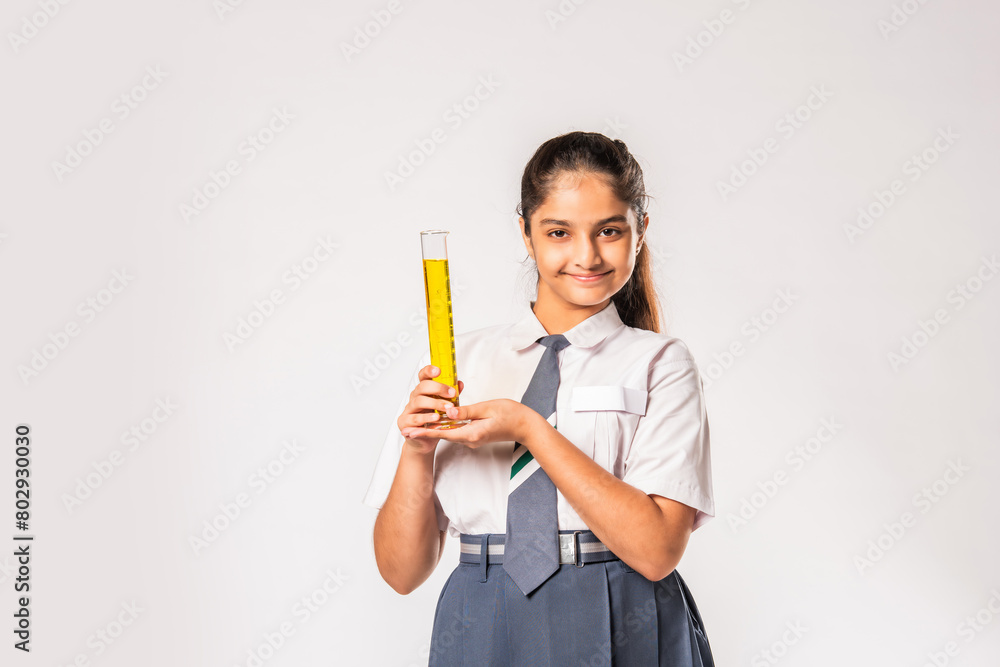 Indian asian small school girl in uniform holding flask with chemical against white background Indian asian small school girl in uniform holding flask with chemical against white background