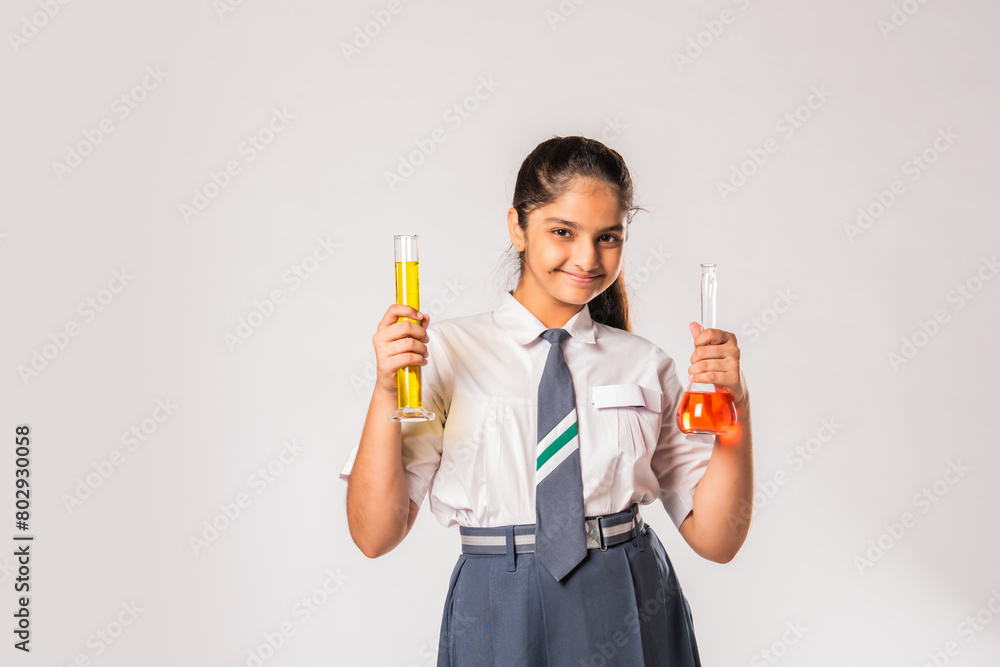 Fototapeta premium Indian asian small school girl in uniform holding flask with chemical against white background