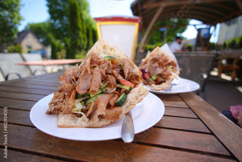 Photography A doner kebab on a wooden table outdoors