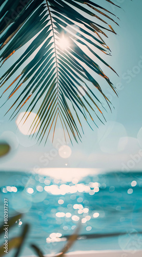 serene view of a sparkling sea through the silhouette of palm leaves  with sunlight filtering through and creating a shimmering effect on the water s surface