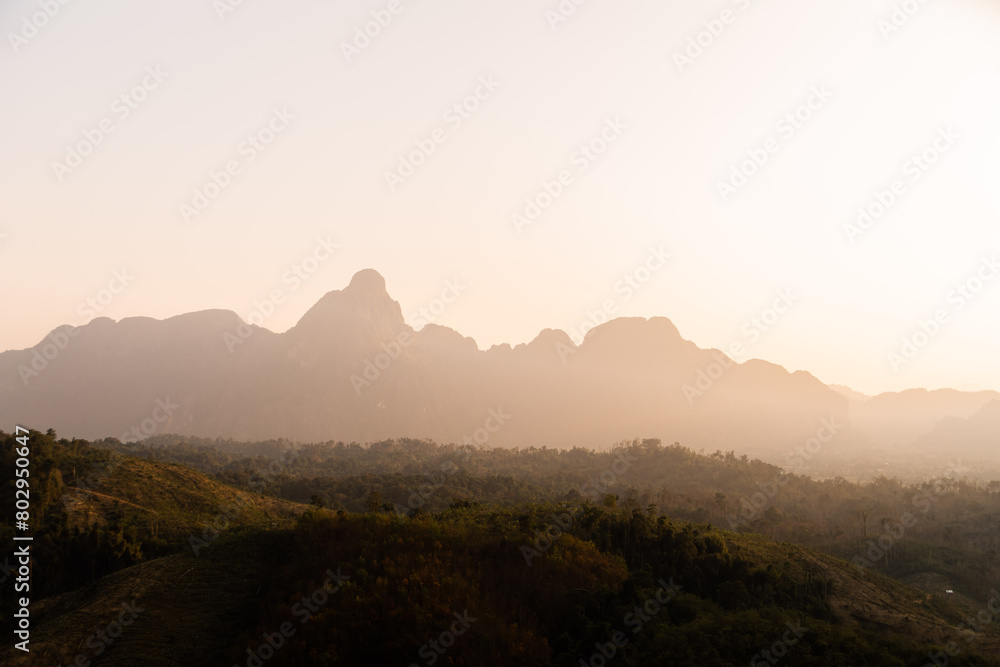 Obraz premium golden sunrise over the defined mountains in Vang Vieng, the adventure capital of Laos