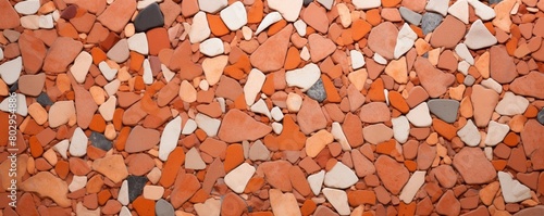A close up of a pile of small and medium sized rocks that are mostly red, orange, and white in color.
