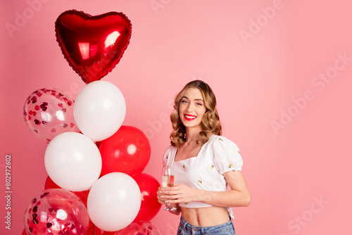 Photo portrait of lovely young woman balloons hold champagne glass dressed stylish white garment hairdo isolated on pink color background