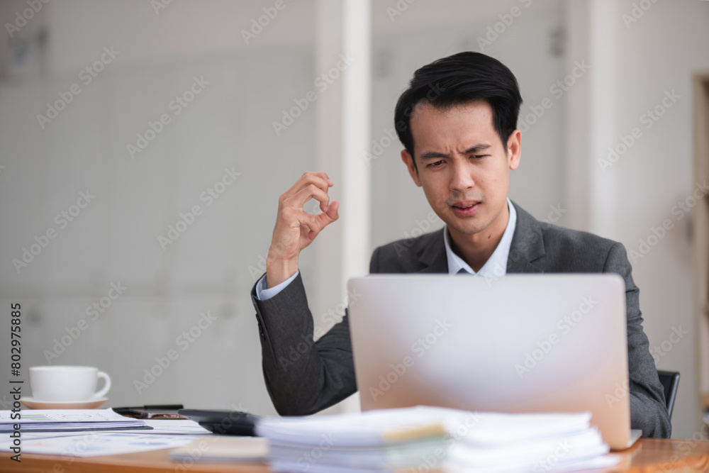 Unhappy young businessman feeling bored or disappointed while sitting in the office Distracted male employee feeling tired from monotonous work Unhappy young businessman feeling bored or disappointed while sitting in the office Distracted male employee feeling tired from monotonous work