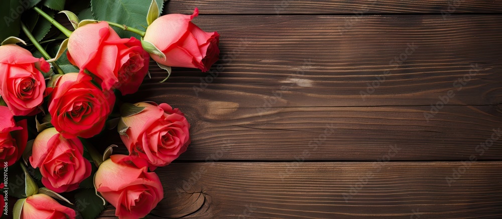 A copy space image displaying roses and a card placed against a rustic wooden background A copy space image displaying roses and a card placed against a rustic wooden background