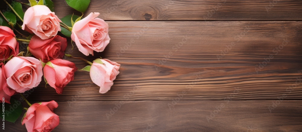A copy space image displaying roses and a card placed against a rustic wooden background