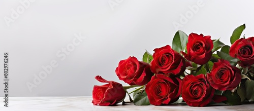 A bouquet of red roses on a table with a white background and copy space for an image