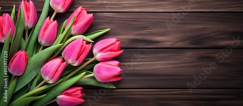 A beautiful arrangement of tulips is placed on a wooden table creating an appealing border design It is perfect for a copy space image